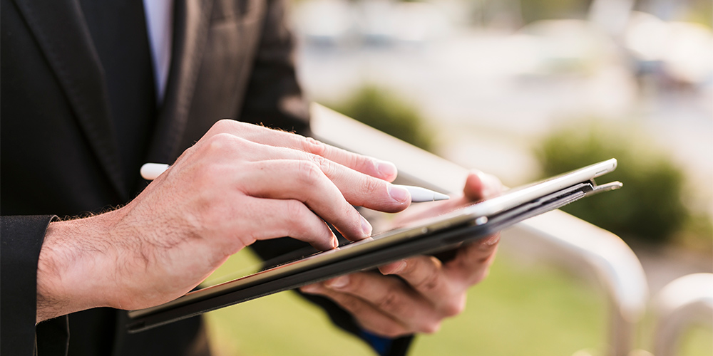 Hombre con traje escribiendo en tablet